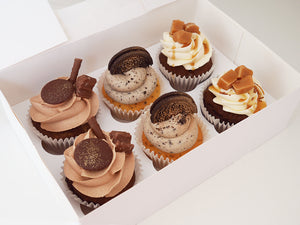 A box of mixed flavoured cupcakes including Oreo cookie, chocolate, caramel and Biscoff flavours